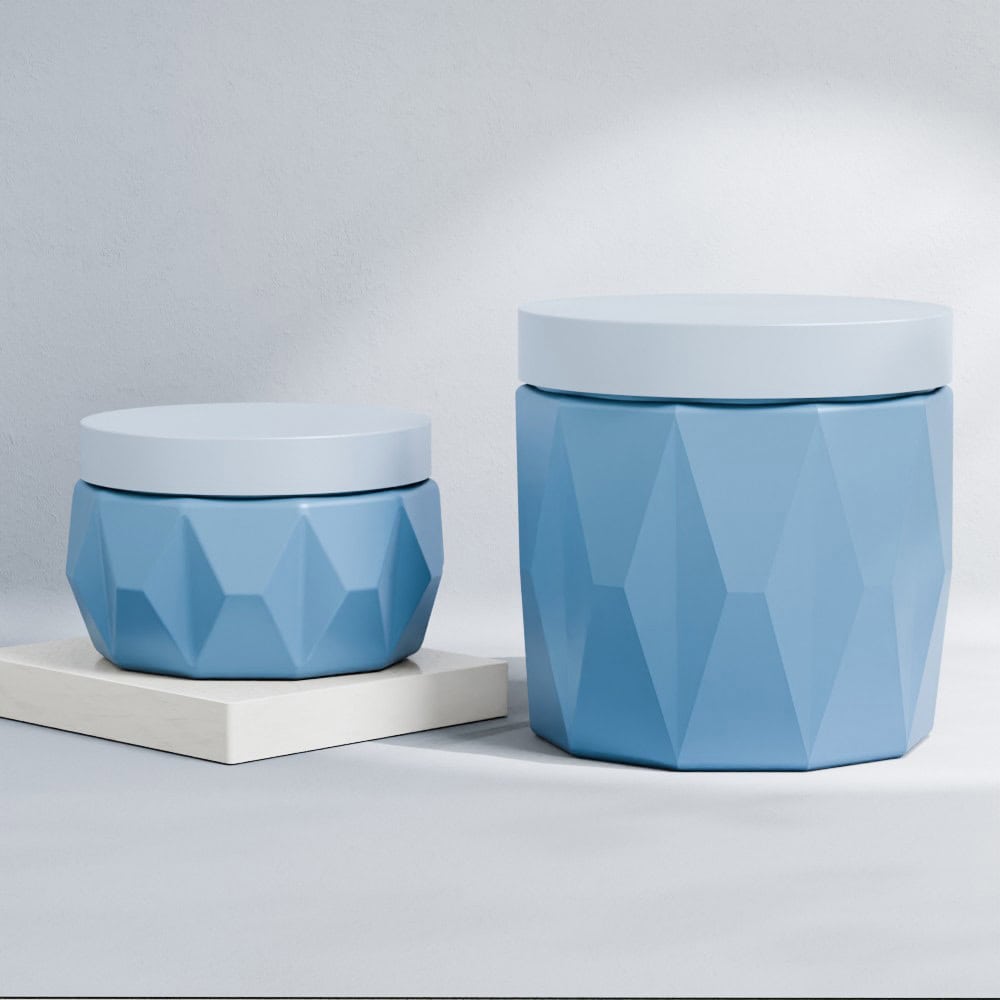 Blue geometric cosmetic jars with white lids for skin care products.