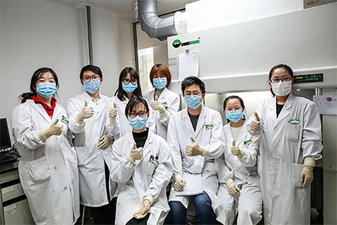 Packaging team at Somewang Packaging facility, showcasing professionals in lab coats and masks.