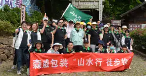 Group of employees from Somewang Packaging outdoors with banners and uniforms.
