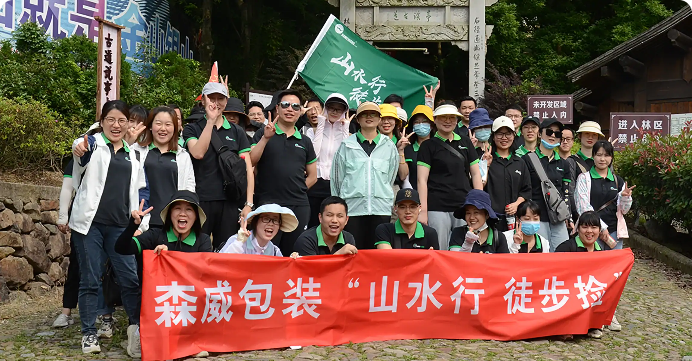Group of employees from Somewang Packaging outdoors with banners and uniforms.