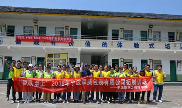 Group of employees holding a banner at Somewang Packaging training event.