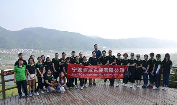 Somewang Packaging team photo outdoors with scenic mountain view.