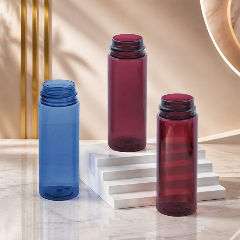 Three colorful PET bottles for foam packaging on a marble surface.
