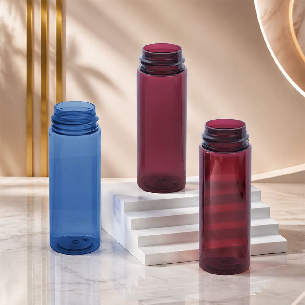 Three colorful PET bottles for foam packaging on a marble surface.