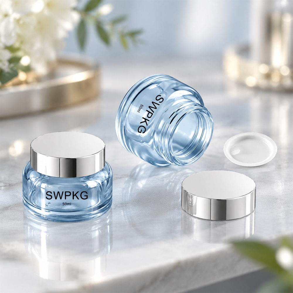 Elegant 50ml glass jars with silver lids for packaging cosmetics or skincare products.