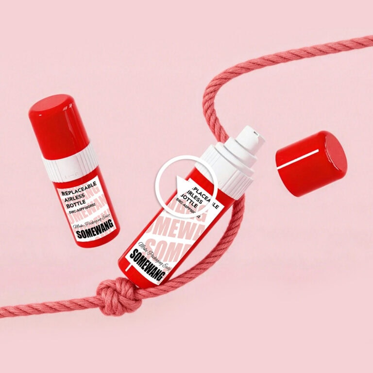Replaceable airless bottle with red cap and pink rope on pink background.